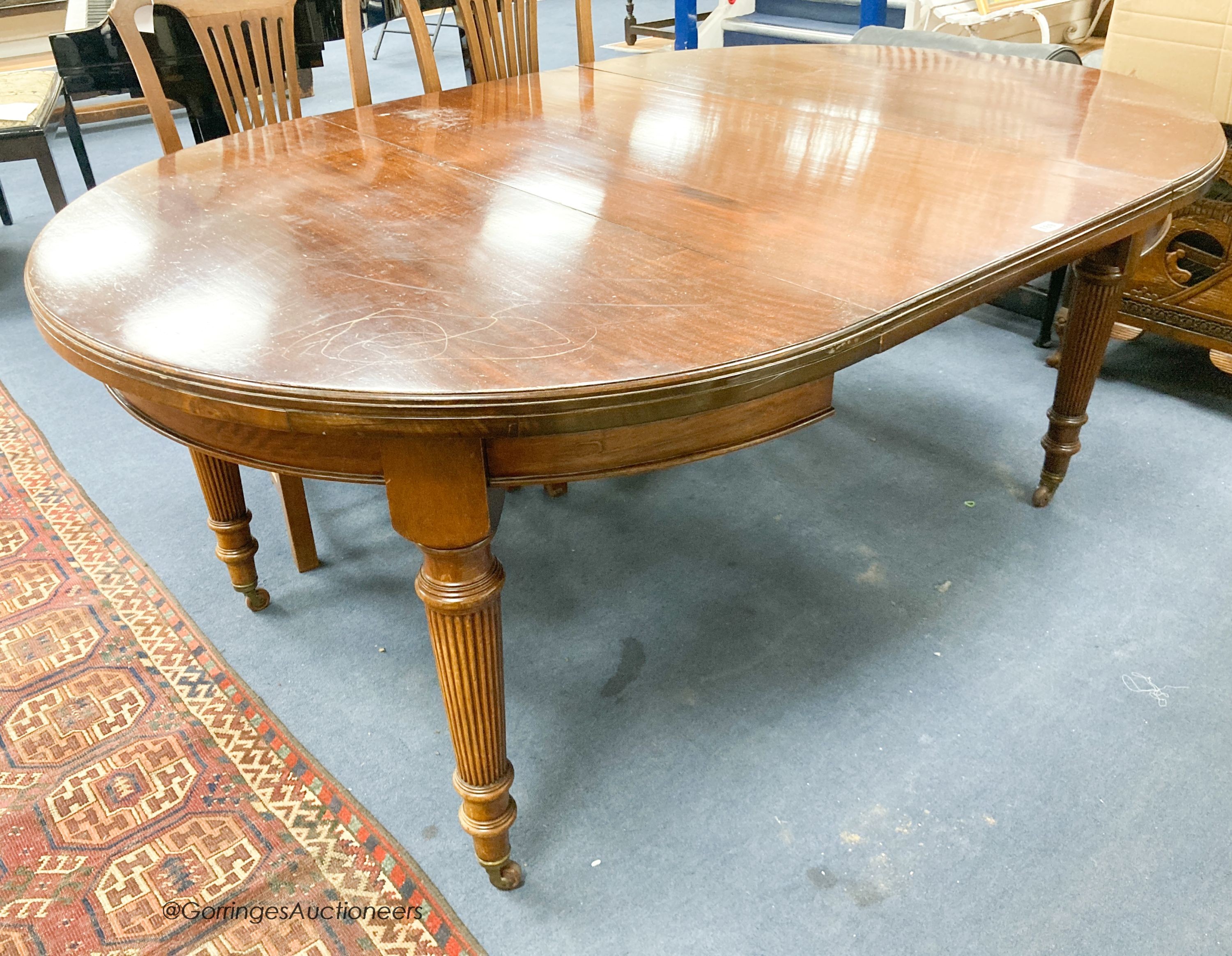 An Edwardian mahogany oval extending dining table, length 180cm extended with one spare leaf, width 120cm, height 74cm together with four George III style mahogany dining chairs